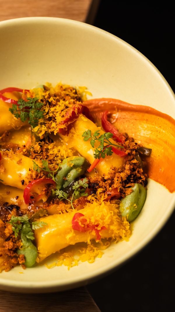 pepper & egg agnolotti, roasted bells, walnut-cruschi, cured egg yolk